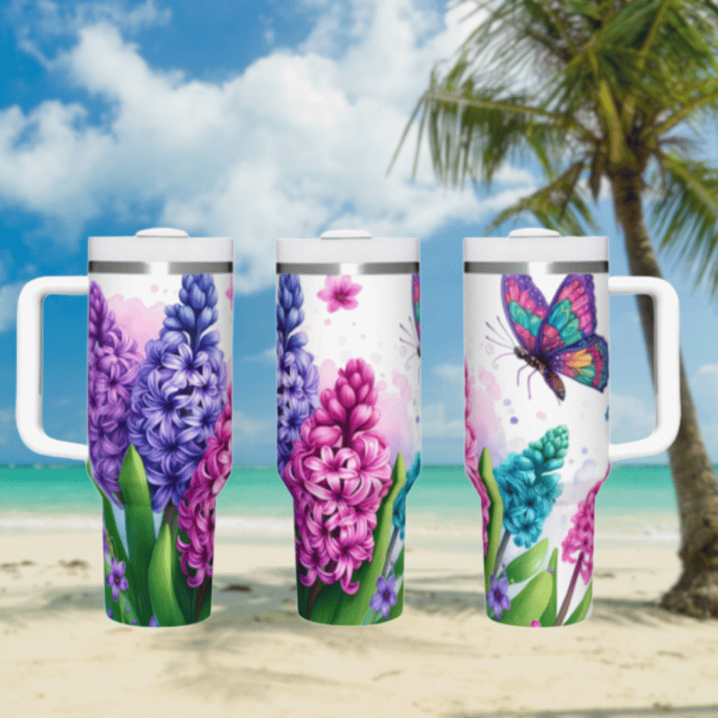 three travel mugs on a beach with a palm tree in the background