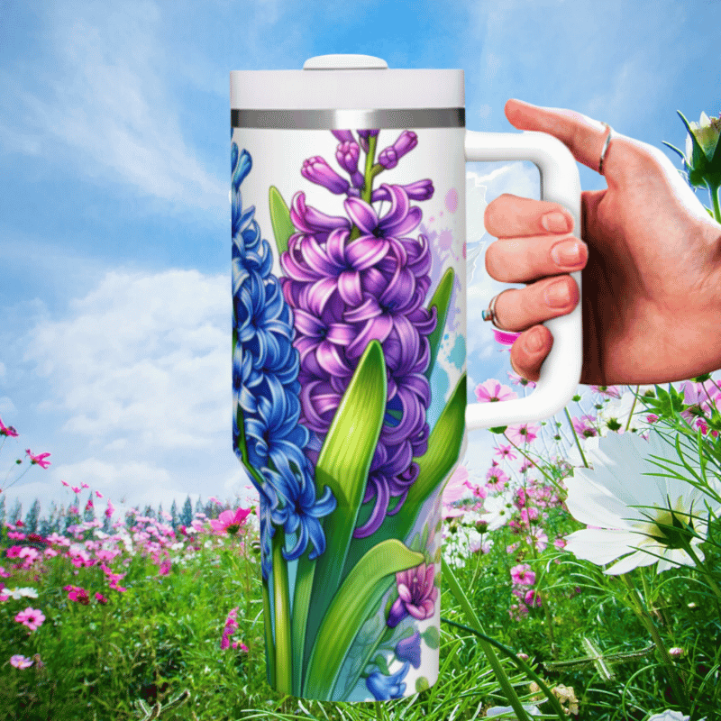 a hand holding a coffee mug in a field of flowers