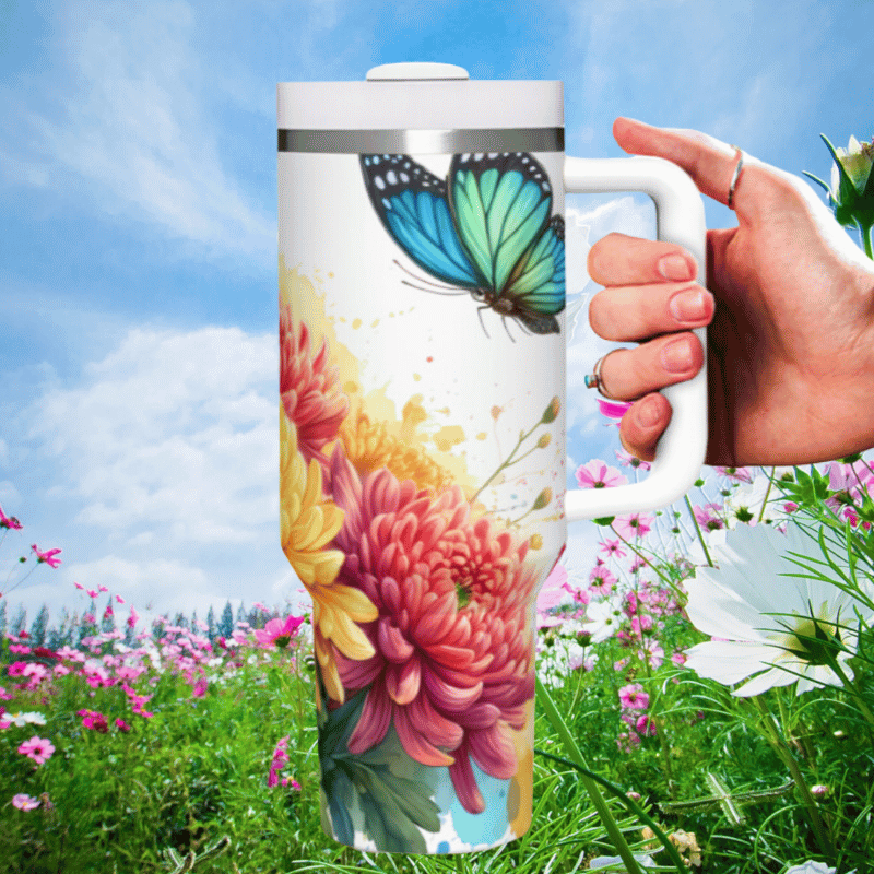 a hand holding a coffee mug in a field of flowers