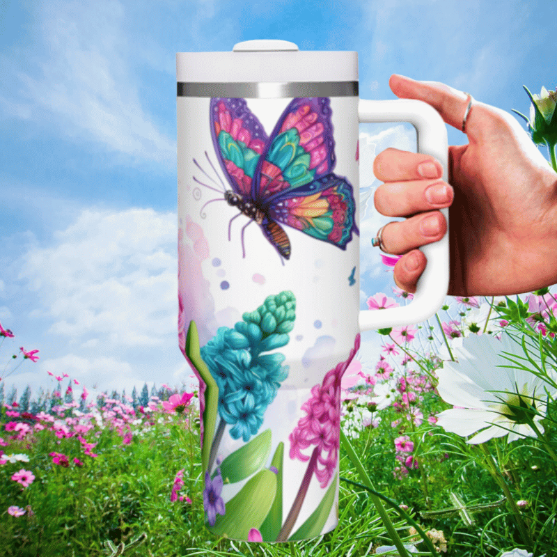 a hand holding a coffee mug in a field of flowers