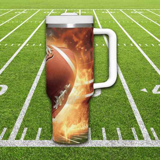 a mug with a football on it sitting on a football field