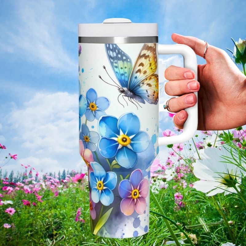 a hand holding a travel mug with a butterfly on it