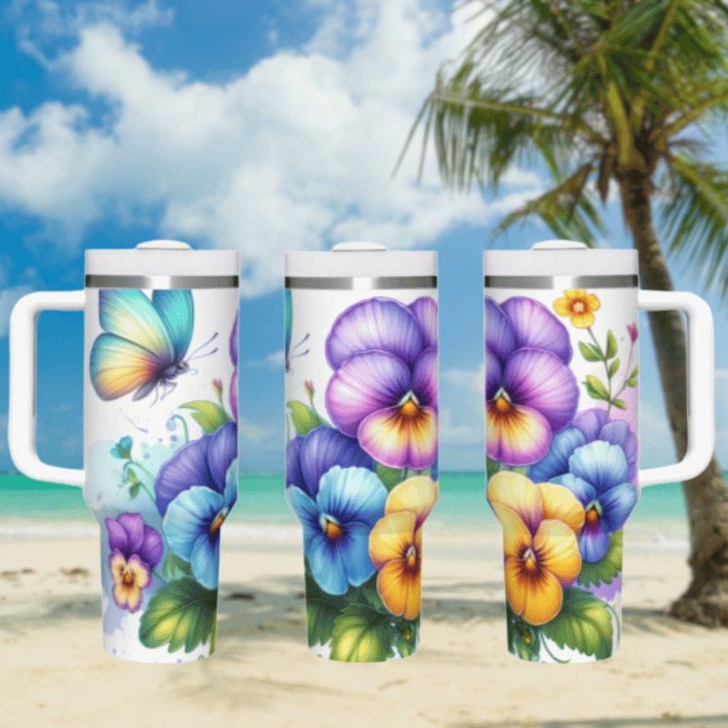 three travel mugs on a beach with flowers painted on them