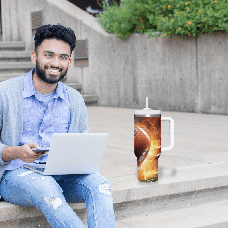 a man sitting on steps with a laptop and a mug