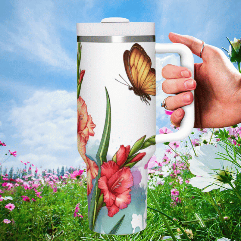 a hand holding a coffee mug in a field of flowers