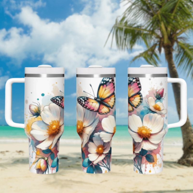 three travel mugs on a beach with a palm tree in the background