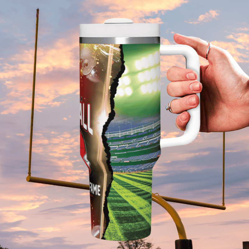 a hand holding a coffee mug with a picture of a stadium