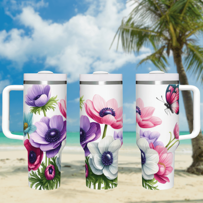 three travel mugs on a beach with a palm tree in the background