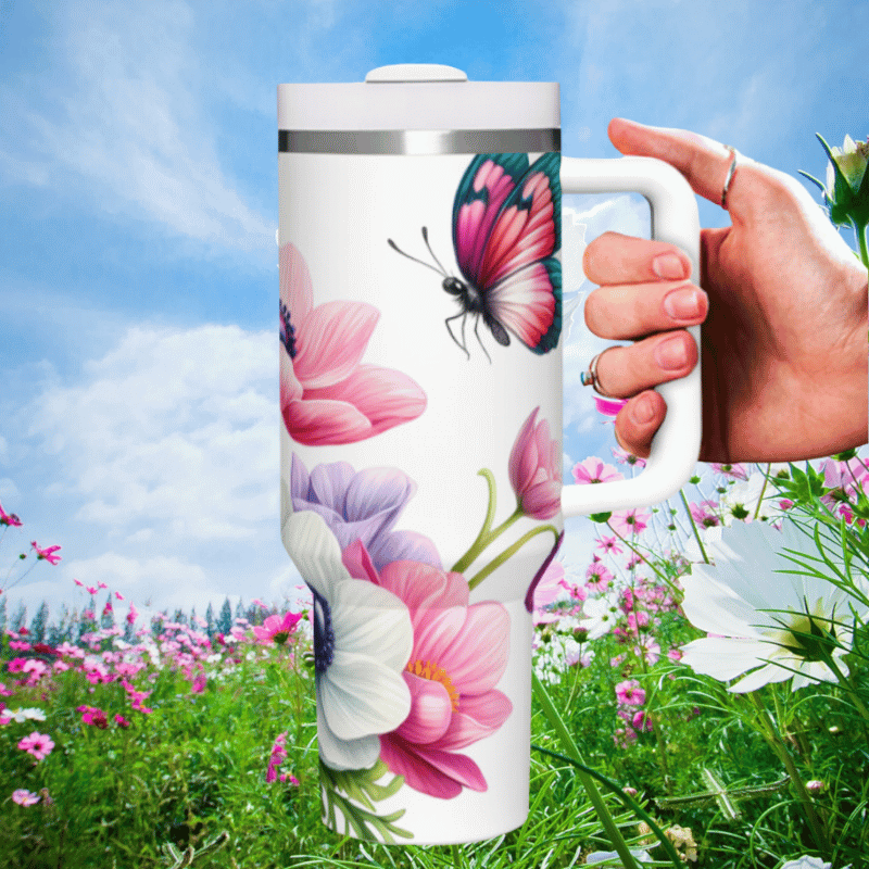 a hand holding a coffee mug in a field of flowers