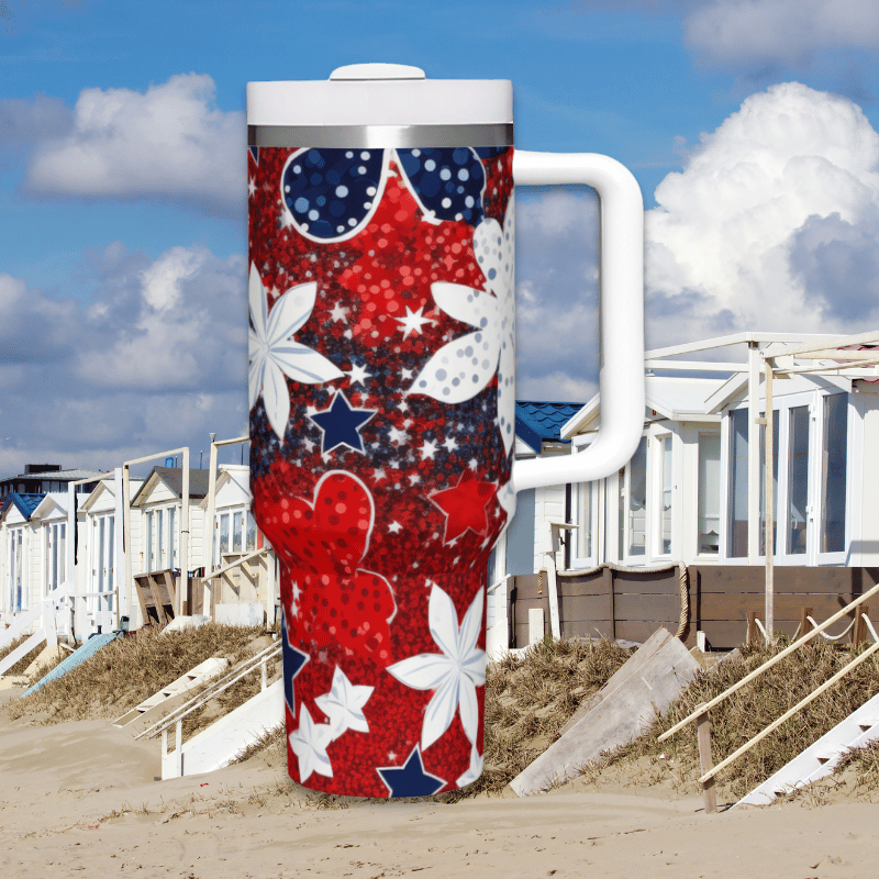 a red, white and blue travel mug sitting on the beach