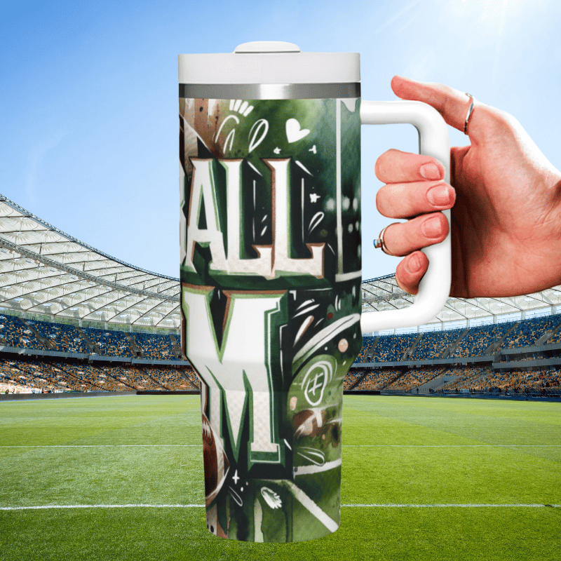 a hand holding a coffee mug in front of a stadium