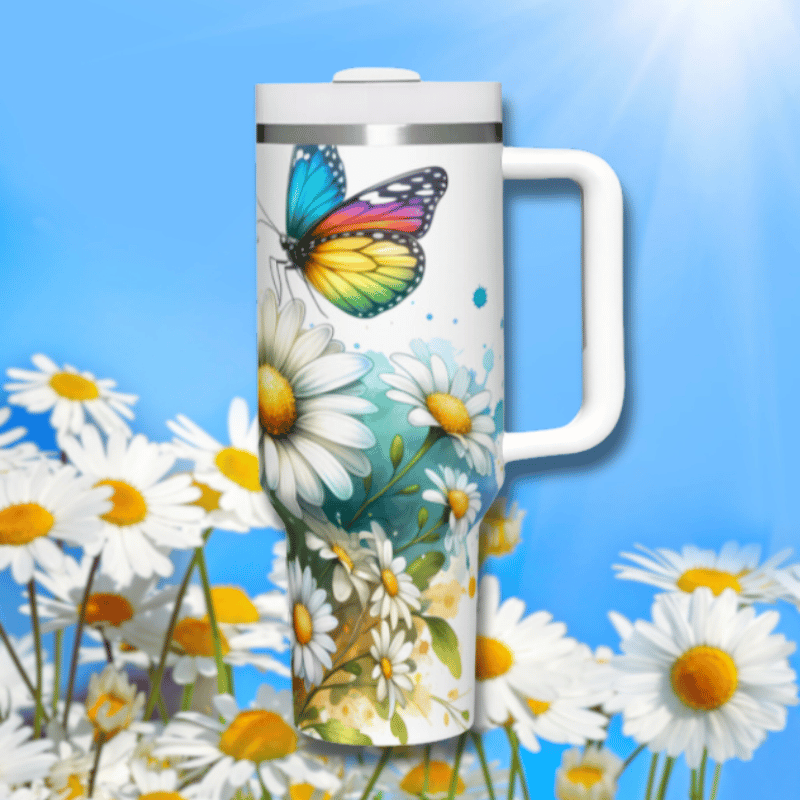 a colorful butterfly painted on a travel mug in a field of daisies