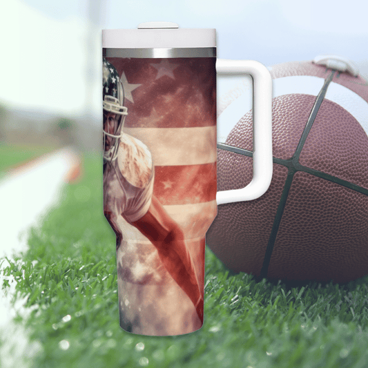 a football and american flag travel mug sitting in the grass