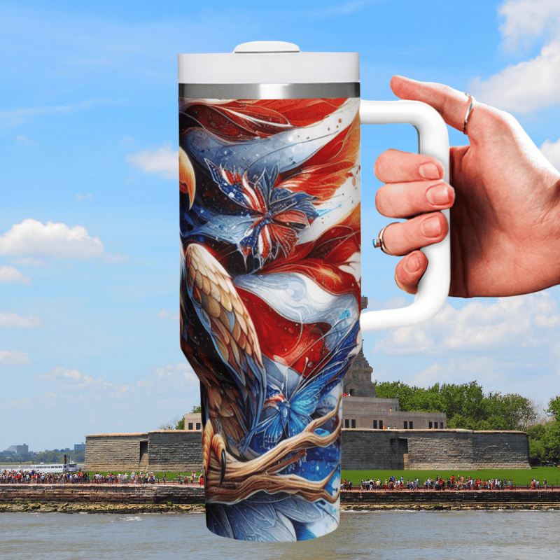 a hand holding a coffee mug in front of a body of water