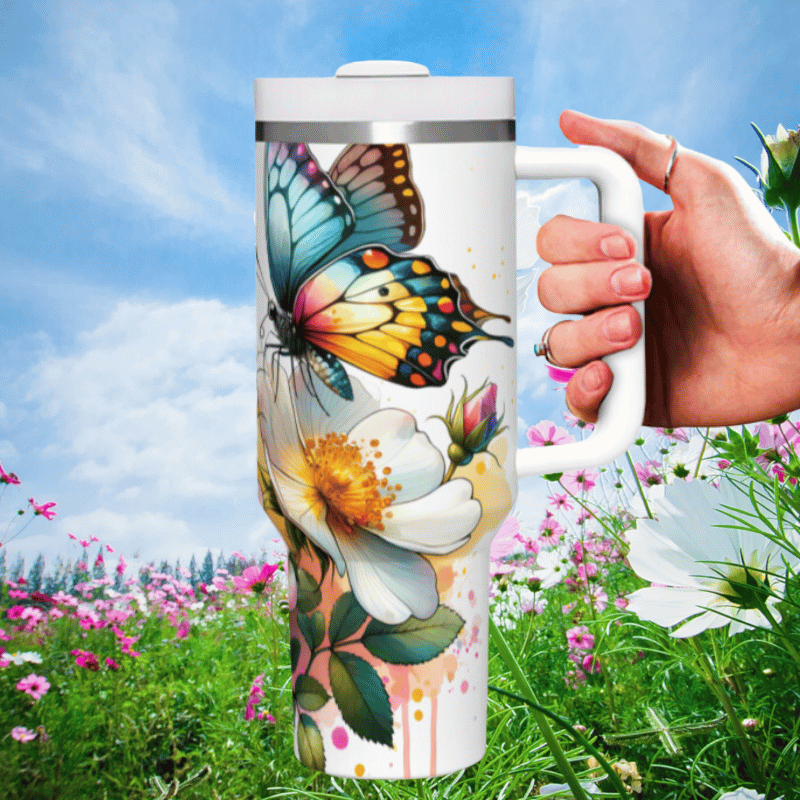 a hand holding a coffee mug in a field of flowers