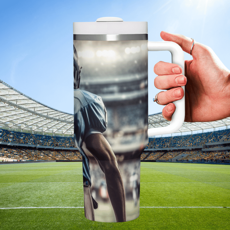 a hand holding a coffee mug in front of a stadium